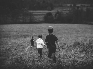 Jungs laufen über eine Wiese